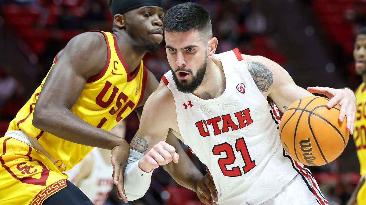 Utah Utes forward Dusan Mahorcic (21) drives into USC Trojans forward Chevez Goodwin (1) during the game at the Huntsman Center in Salt Lake City on Saturday, Jan. 22, 2022.