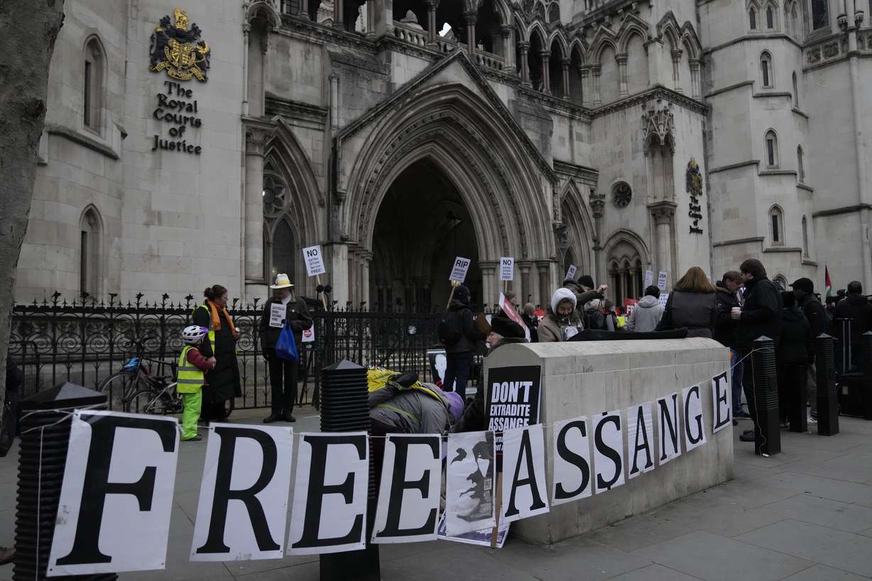 Supporters of Julian Assange stand outside the High Court, in London, Monday.