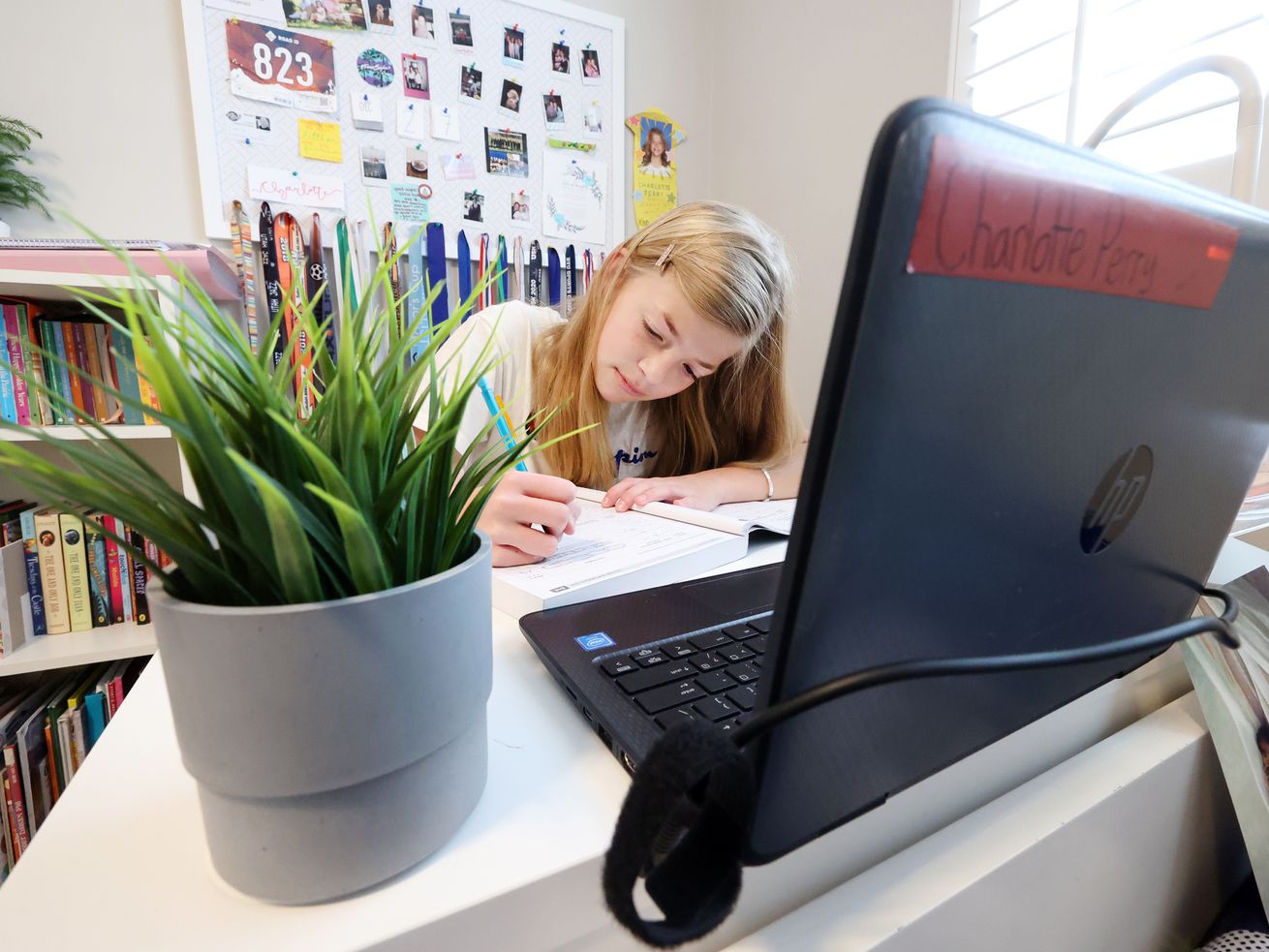Rachel Perry and her sister, Charlotte Perry,
participate in school via their computers at home in Salt Lake City
on Friday.