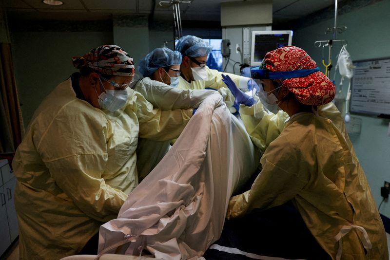 Medical staff members treat a coronavirus disease patient in their isolation room in the intensive care unit at Western Reserve Hospital in Cuyahoga Falls, Ohio, on Jan. 4.