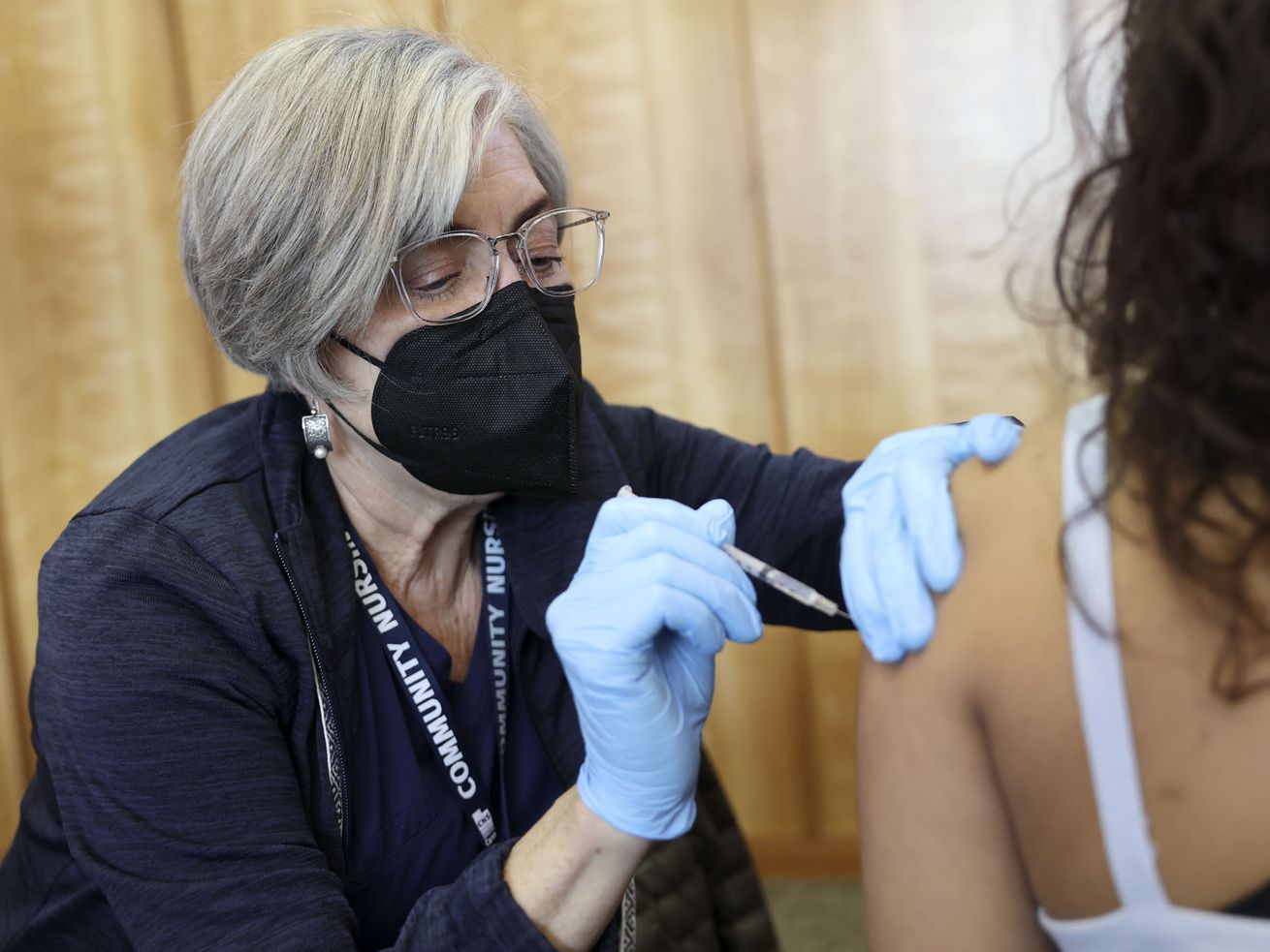 Community Nursing Services nurse Janie Wilson gives University of Utah freshman Bryana Lopez her COVID-19 booster shot at the Olpin Student Union at the University of Utah in Salt Lake City on Thursday, Jan. 20.