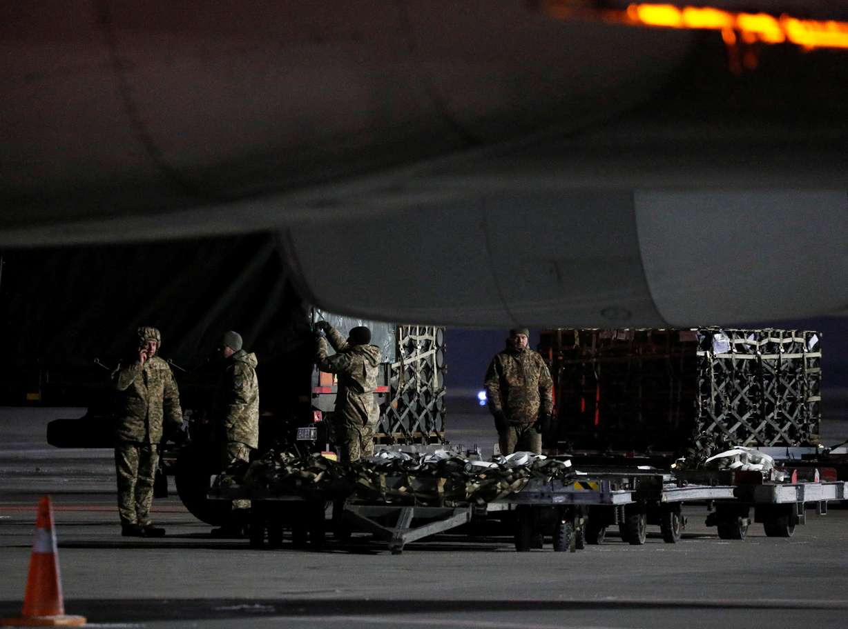 Ukrainian service members unload a shipment of military aid delivered as part of the United States of America's security assistance to Ukraine, at the Boryspil International Airport outside Kyiv, Ukraine, Tuesday.