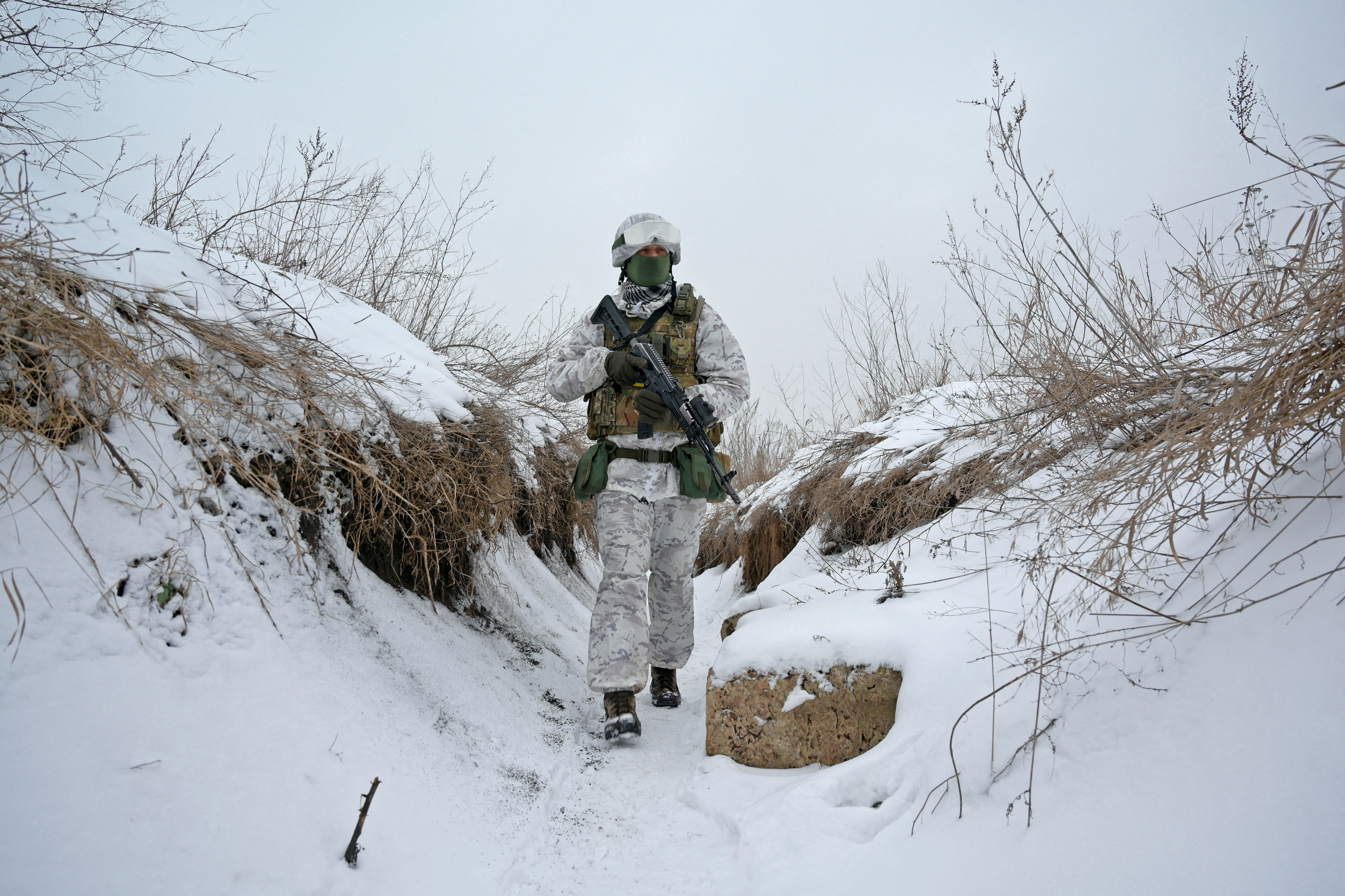 A service member of the Ukrainian armed forces walks at combat positions near the line of separation from Russian-backed rebels outside the town of Avdiivka in Donetsk Region, Ukraine, Tuesday.