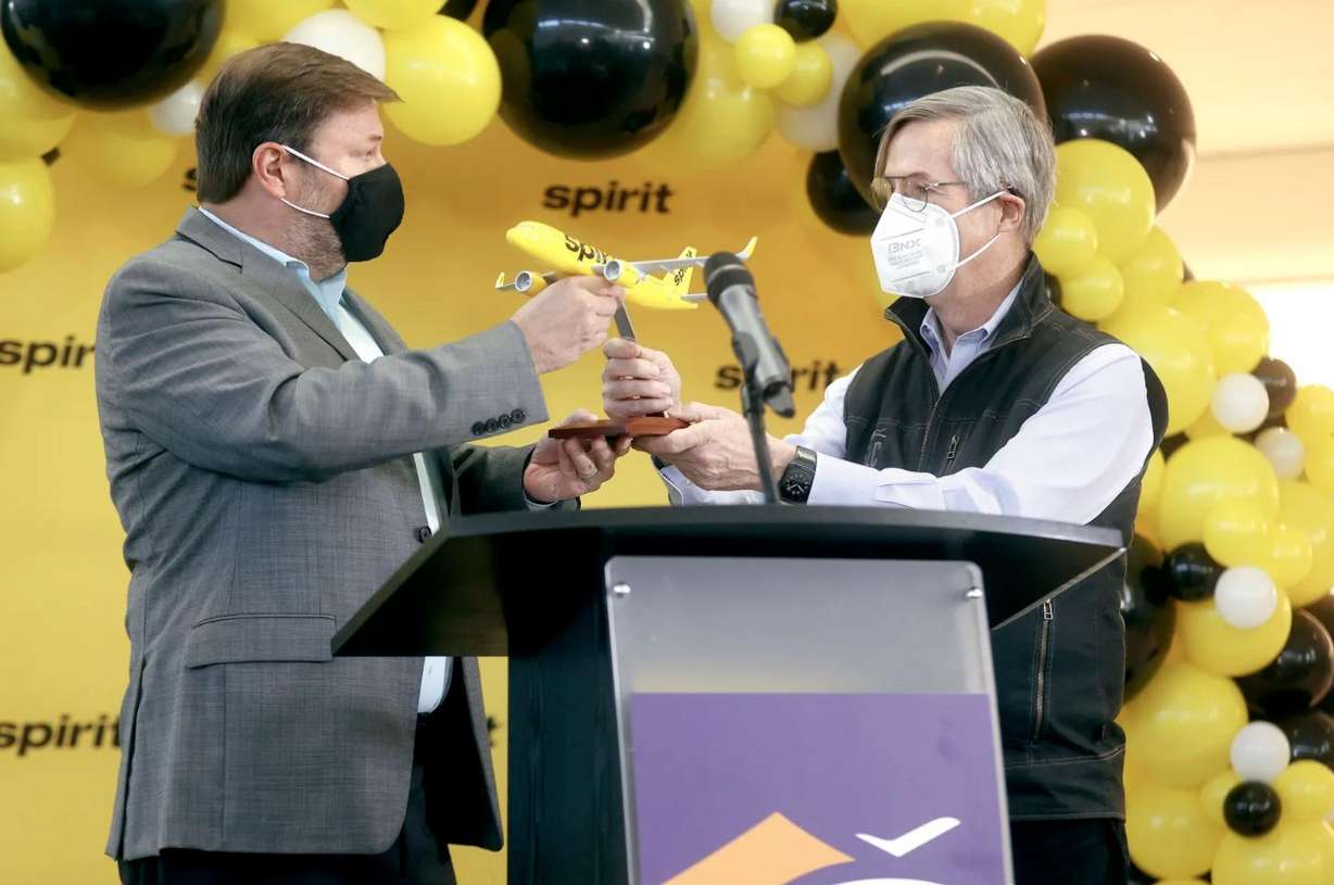 John Kirby, Spirit Airlines network planning vice president, gives a model plane to Salt Lake City Department of Airports executive director Bill Wyatt after announcing that Spirit Airlines will begin service to and from Salt Lake City in May, during a press conference at Salt Lake City International Airport in Salt Lake City on Tuesday, Jan. 25, 2022.