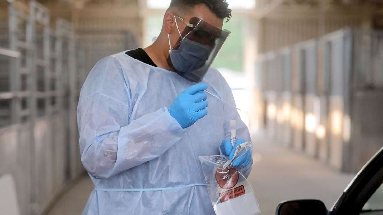 Xander Yazzie, a Utah National Guard service member,
performs a COVID-19 test at the Utah State Fairpark in Salt Lake
City on Aug. 16, 2021.