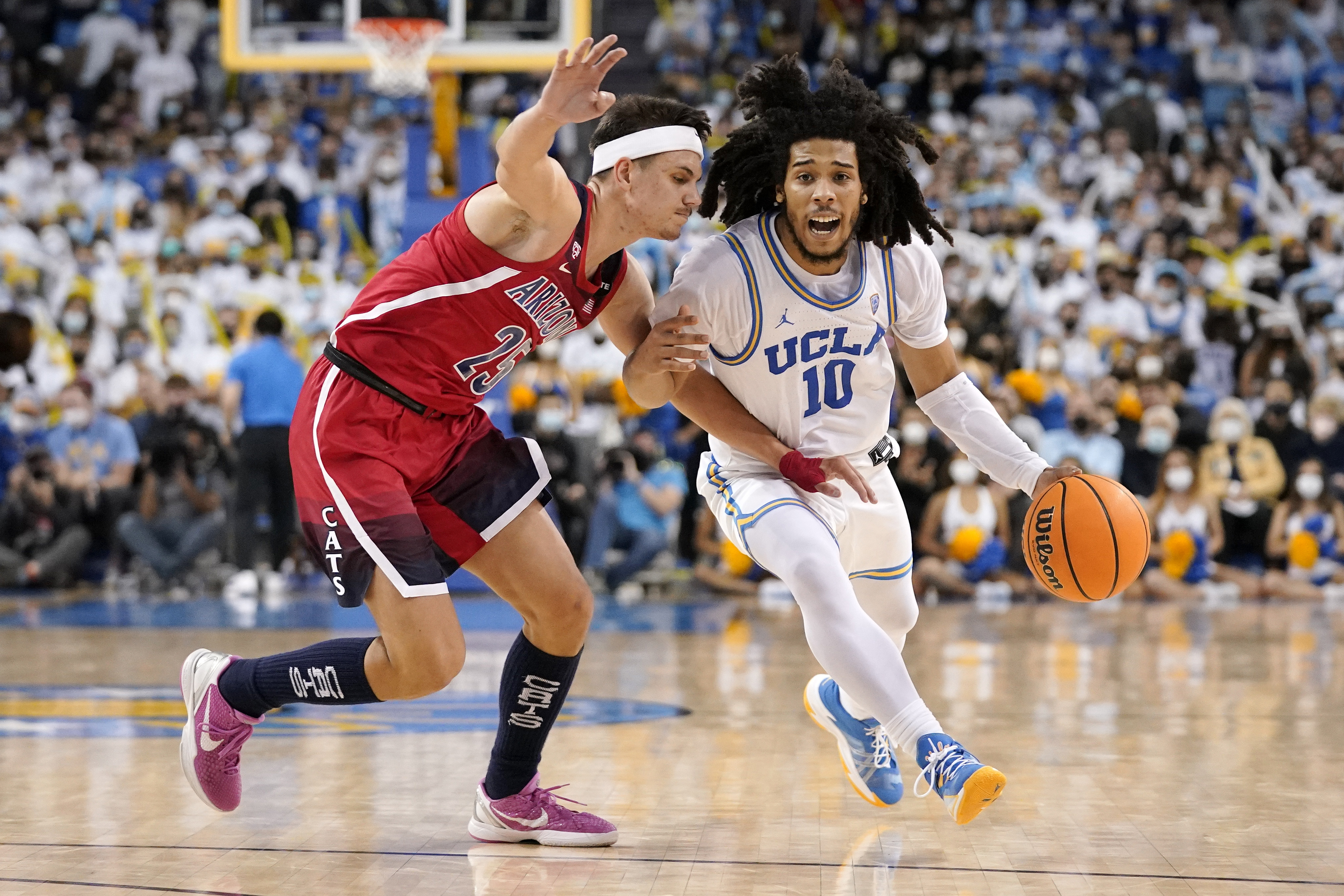 UCLA guard Tyger Campbell, right, drives toward the basket as Arizona guard Kerr Kriisa defends during the second half of an NCAA college basketball game Tuesday, Jan. 25, 2022, in Los Angeles.