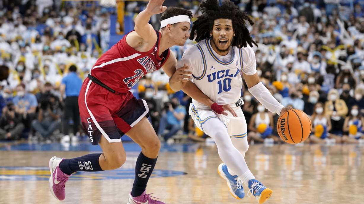 UCLA guard Tyger Campbell, right, drives toward the basket as Arizona guard Kerr Kriisa defends during the second half of an NCAA college basketball game Tuesday, Jan. 25, 2022, in Los Angeles.