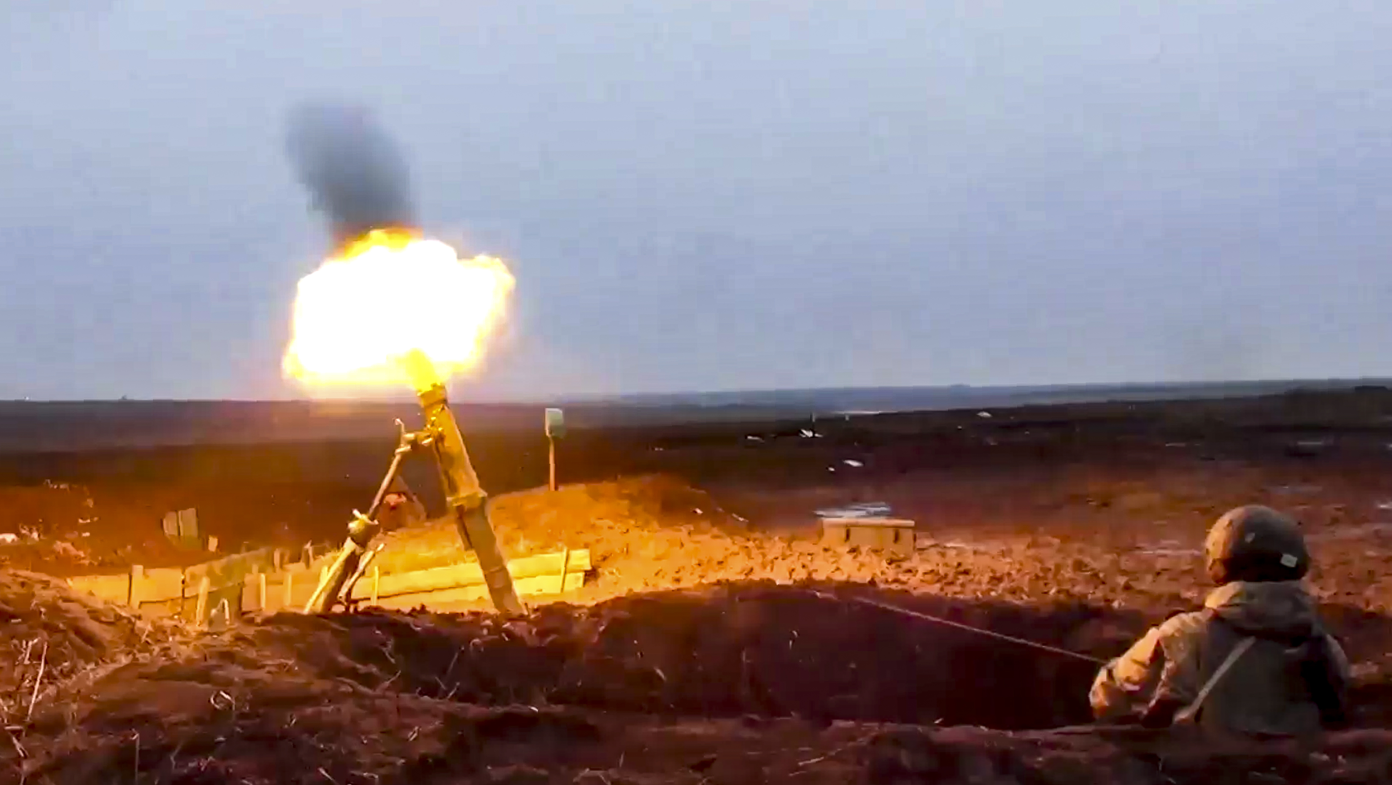 In this photo taken from video provided by the Russian Defense Ministry Press Service on Tuesday, a Russian soldier fires a mortar as he attends a military exercise at a training ground in Russia.