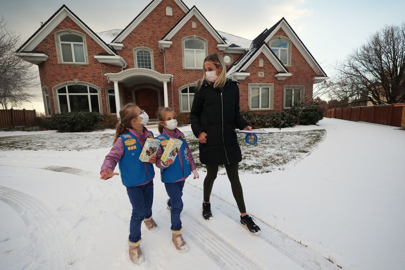 Kalie Agy and her daughters Juliet and Annie go door-to-door selling Girl Scout Cookies in Cottonwood Heights on Tuesday.