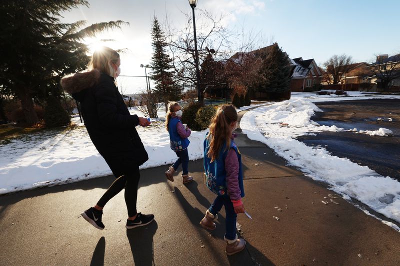 Kalie Agy and her daughters Annie and Juliet go door to
door selling Girl Scout Cookies in Cottonwood Heights on Tuesday.