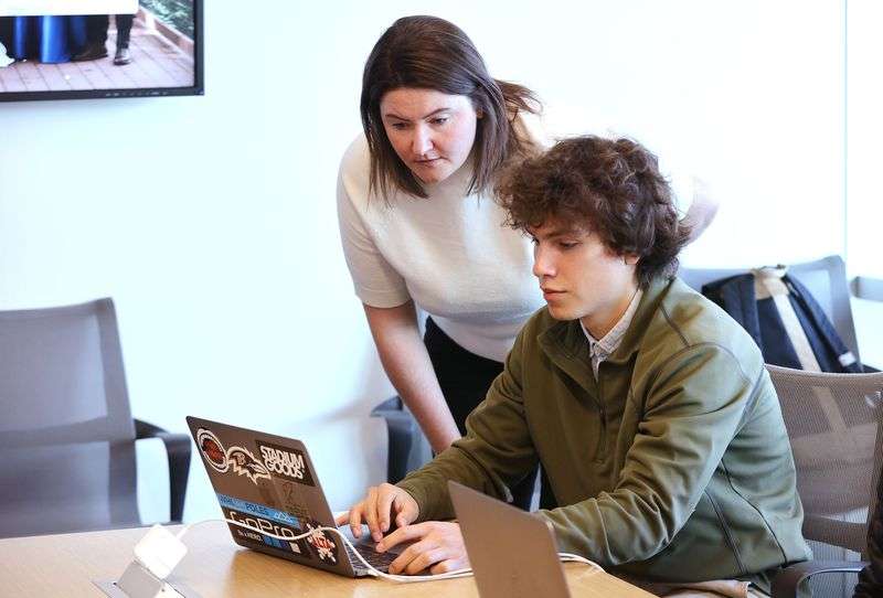 Sorenson Impact Center staffer Charlotte Magee, left,
talks with student Aaron Young as they meet to review applicants
for a new $5 million fund at the University of Utah in Salt Lake
City on Tuesday.