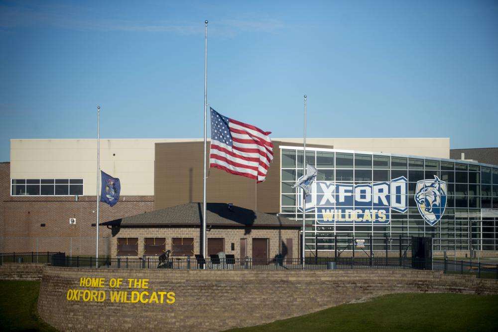 The American flag flies at half-staff on Thursday, Dec. 2, 2021, outside of Oxford High School in Oxford, Mich.