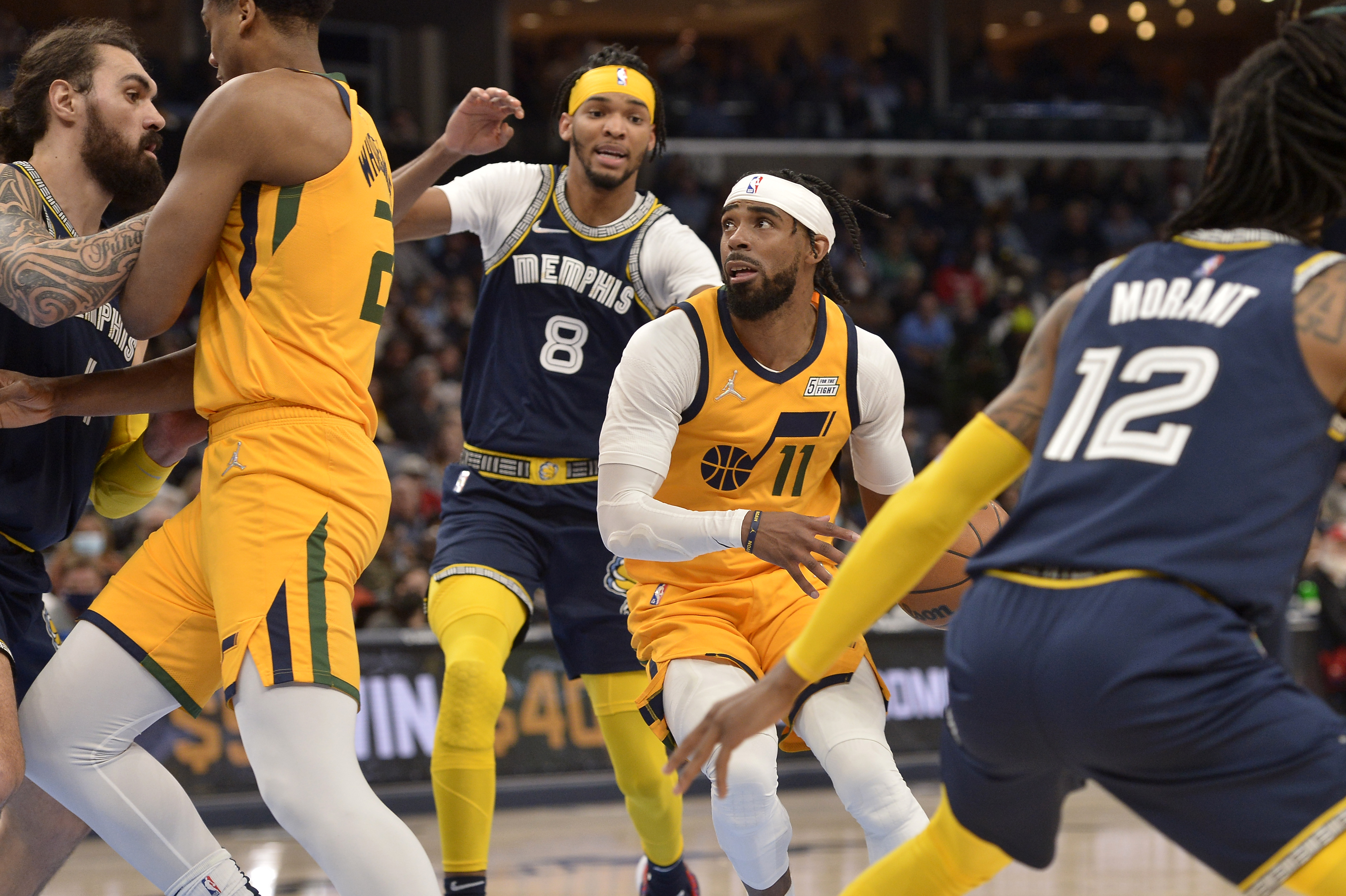Utah Jazz guard Mike Conley (11) handles the ball ahead of Memphis Grizzlies guard Ziaire Williams (8) in the second half of an NBA basketball game Friday, Jan. 28, 2022, in Memphis, Tenn.