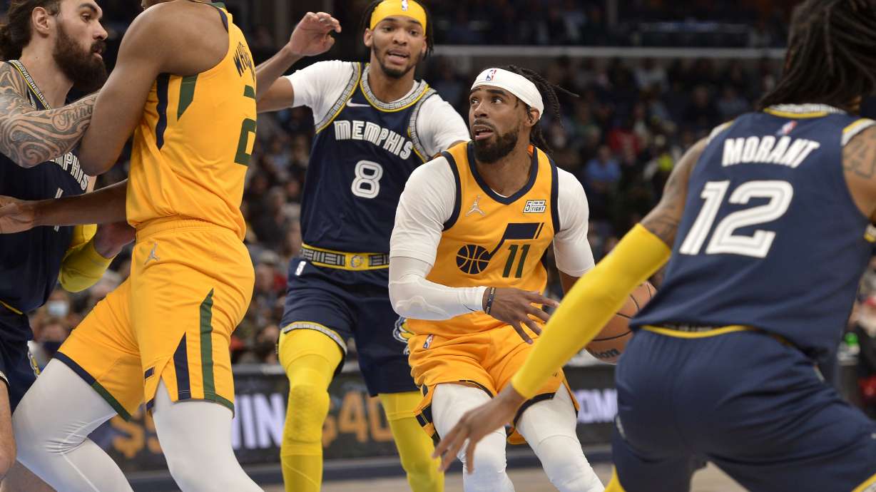 Utah Jazz guard Mike Conley (11) handles the ball ahead of Memphis Grizzlies guard Ziaire Williams (8) in the second half of an NBA basketball game Friday, Jan. 28, 2022, in Memphis, Tenn.