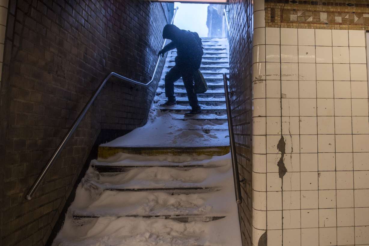 A man carefully walks down the snow covered subway stairs during a snow storm in Bushwick section of Brooklyn borough of New York on Saturday.