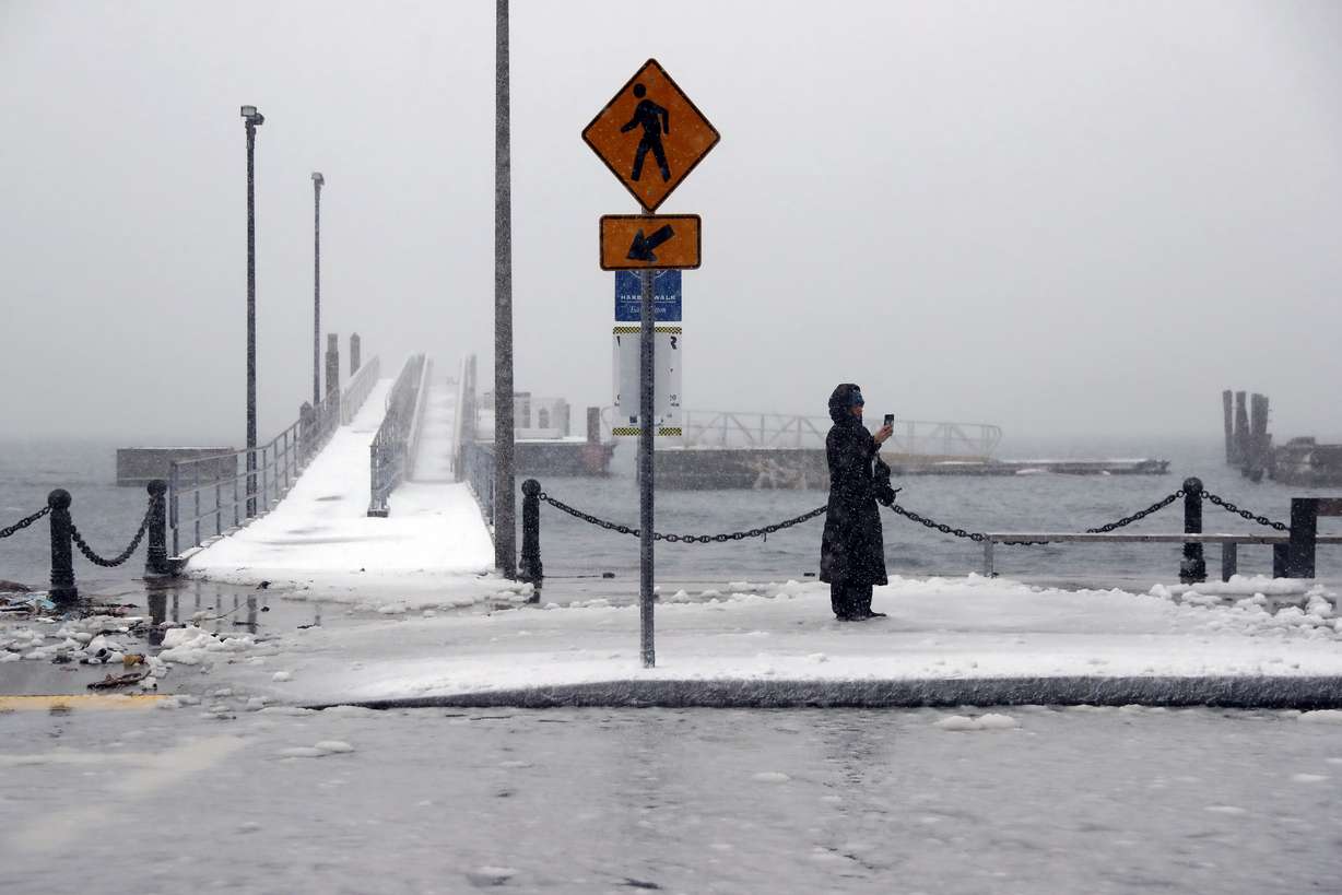 Water from Boston Harbor floods the roadway, Saturday, in the East Boston neighborhood of Boston.
