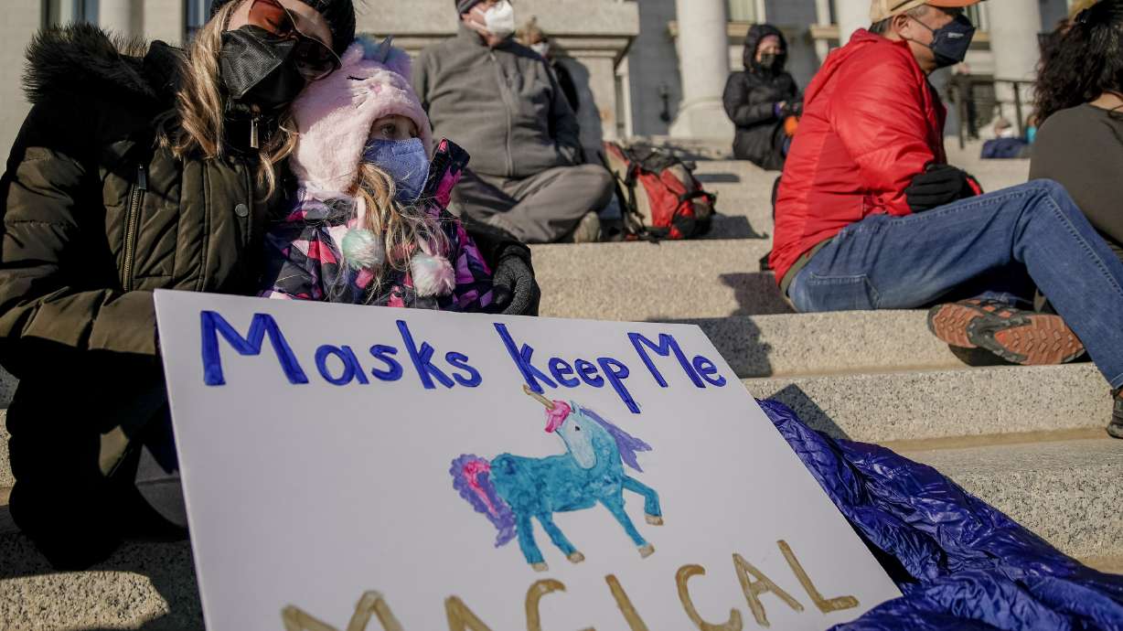 Christine Maugham, left, holds her daughter, Imogen Cracroft, 9, during the Concerned Coalition Public Health Rally at the state Capitol in Salt Lake City on Saturday.