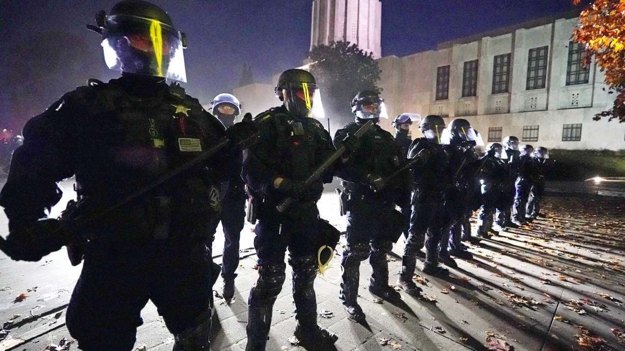 Police line up at the Oregon State Capitol building where demonstrators gathered Nov 7, 2020, in Salem, Ore. A civil rights trial against three former Minneapolis police officers seeks to hold them responsible for not stopping George Floyd's murder under Derek Chauvin's knee — and perhaps strike a blow against longstanding police culture that breeds reluctance to rein in fellow officers.