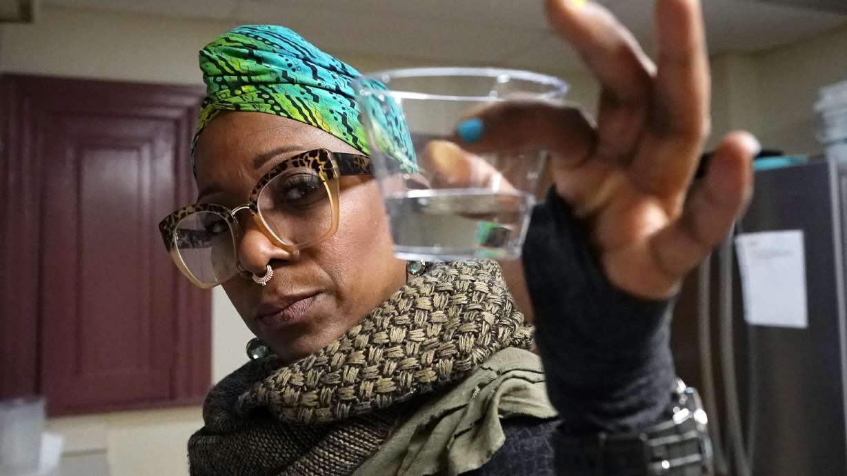Angela Stamps holds a sampling of tap water, Thursday, Jan. 6, in Flint, Mich. After Flint's water crisis, 35% of Black adults in the U.S. said they didn't drink tap water. High-profile cases of lead contamination in predominantly Black cities and a history of deception around the problem have led to a distrust of tap water, which can have long-term health and financial consequences.