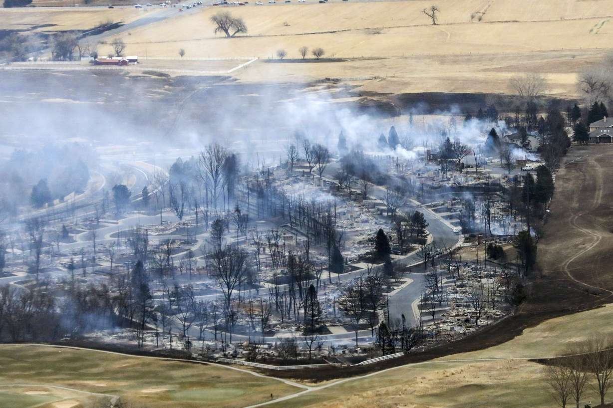 A Boulder County neighborhood smolders after it was was destroyed by a wildfire in this aerial photo from a Colorado National Guard helicopter during a flyover by Colorado Gov. Jared Polis on Dec. 31, 2021.