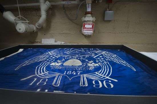 The first Utah state flag made in 1903 placed by pipes in the basement of the Rio Grande Depot in March 2018. The flag has wears and tears with age. It's also one of the many pieces of Utah past in the state's historic collection.