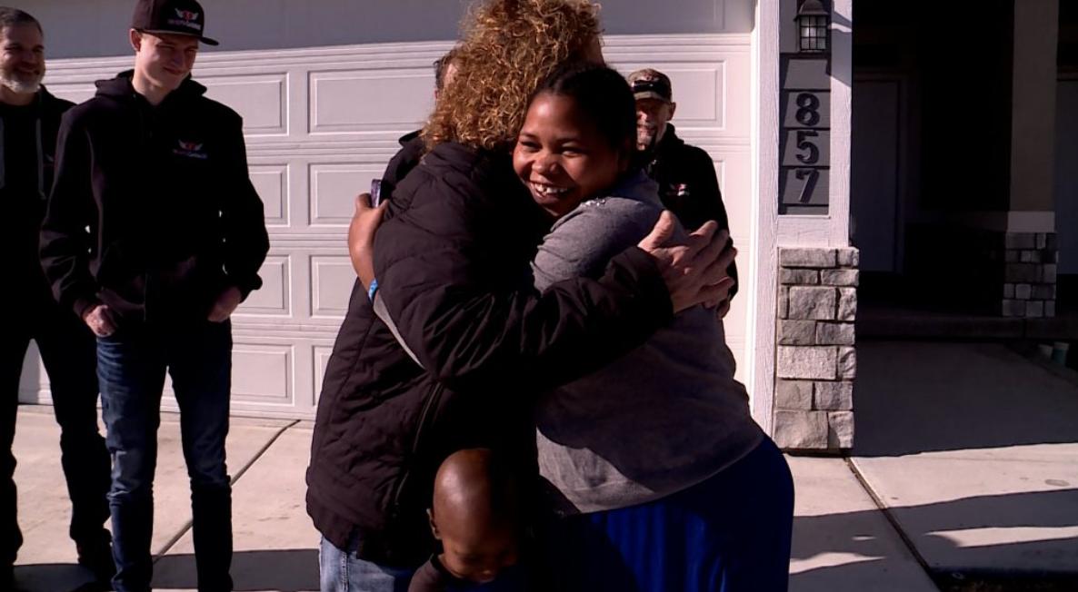 Jimi Pitts and Zyningira Zchimpayi stand in front of the car God's Garage gave to Zchimpayi.