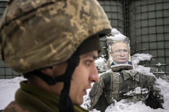 A Ukrainian serviceman speaks, backdropped by a bullet-riddled effigy of Russian President Vladimir Putin, during a media interview at a frontline position in the Luhansk region, eastern Ukraine, Tuesday.