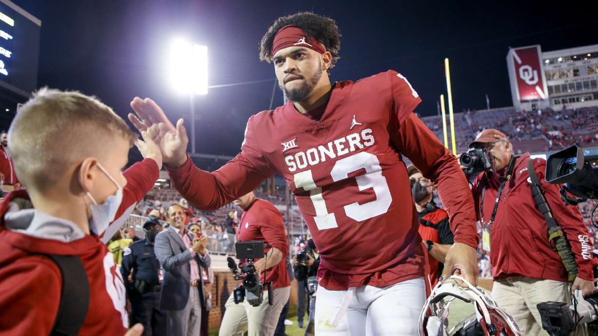 Oklahoma quarterback Caleb Williams (13) celebrates with fans while walking off the field after the team's team's 52-31 win over TCU in an NCAA college football game Saturday, Oct. 16, 2021, in Norman, Okla.