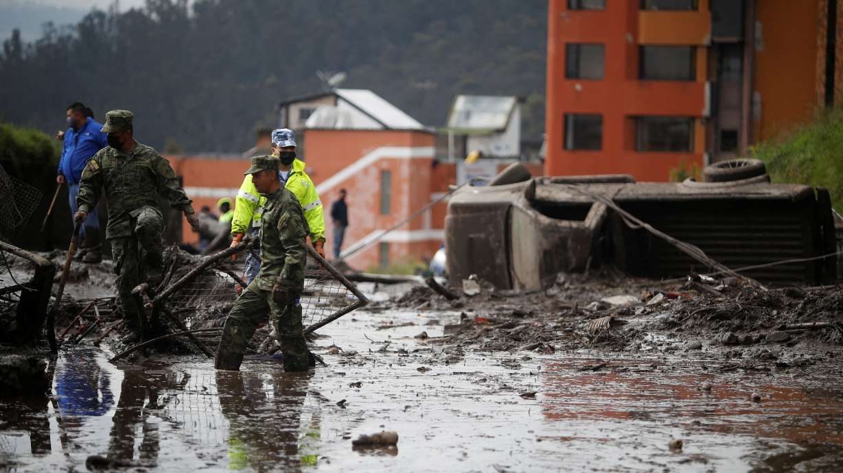 Firefighter rescue crews continue searching homes and streets covered by mud in Quito, Ecuador, Tuesday. The death toll following a Monday night landslide in the area rose on Tuesday to at least 22 people, with 47 reported injured so far.