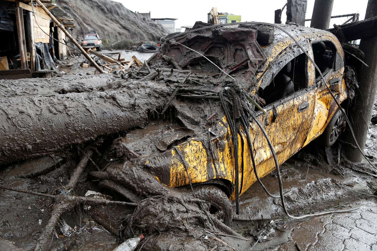 A car is seen in an area of a landslide in Quito, Ecuador, Tuesday. The death toll following a Monday night landslide in the area rose on Tuesday to at least 22 people, with 47 reported injured so far.