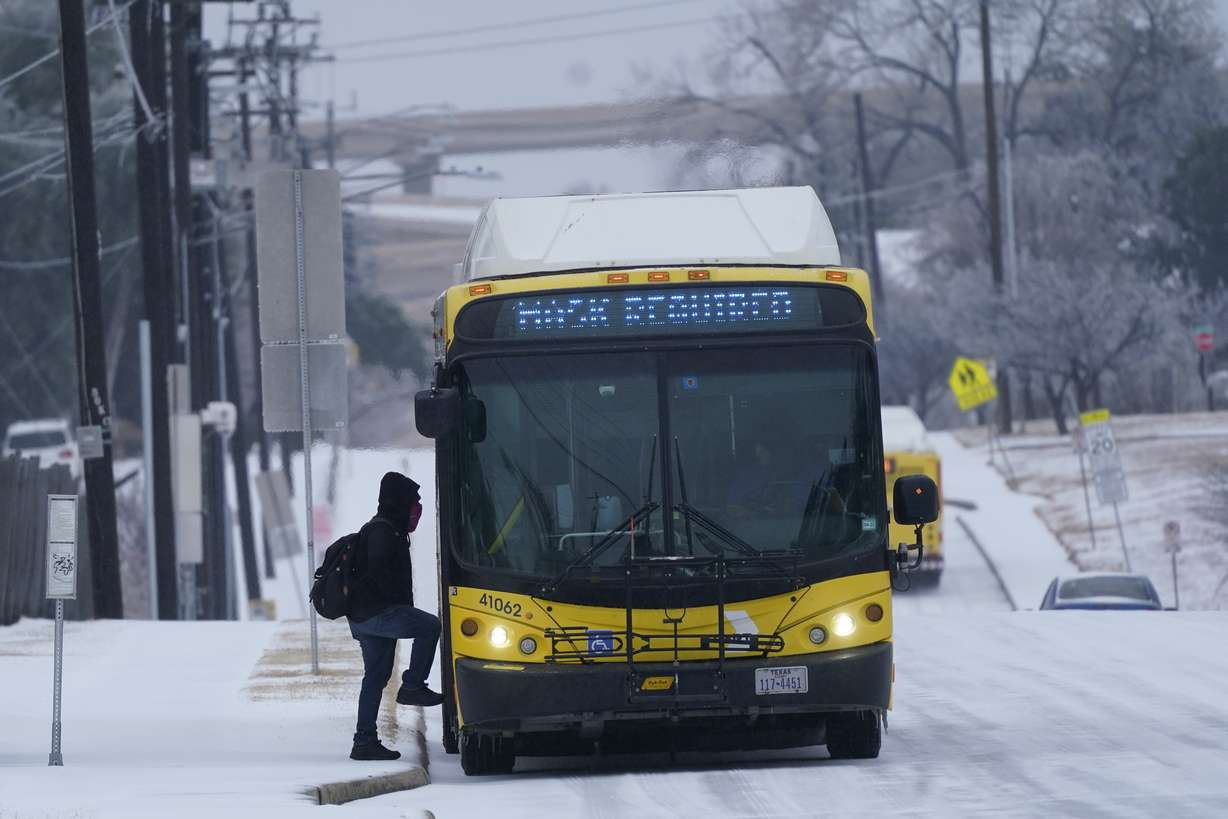 A rider steps onto a bus during a light freezing rain in Dallas, Thursday.
