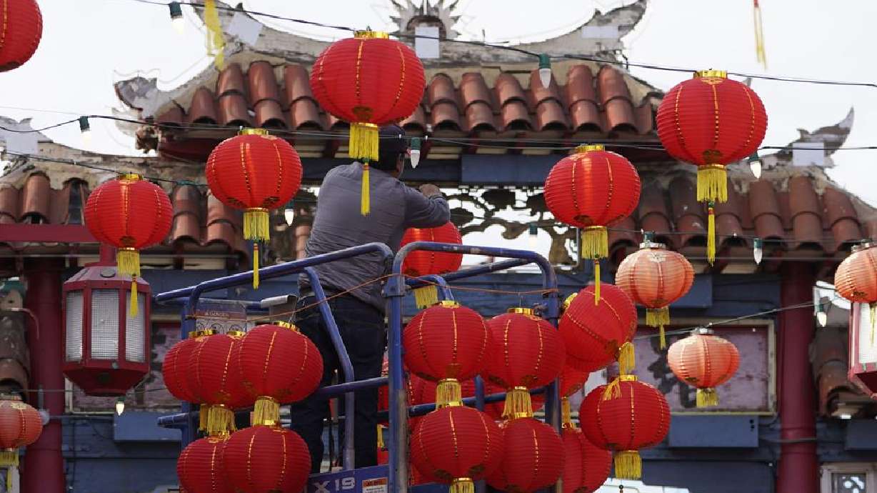 Worker Jose Vargas, originally from Michoacan, Mexico, exchanges hundreds of color-faded Red Chinese lanterns with new ones ahead of the Lunar New Year celebrations in the Chinatown district of Los Angeles, Friday.