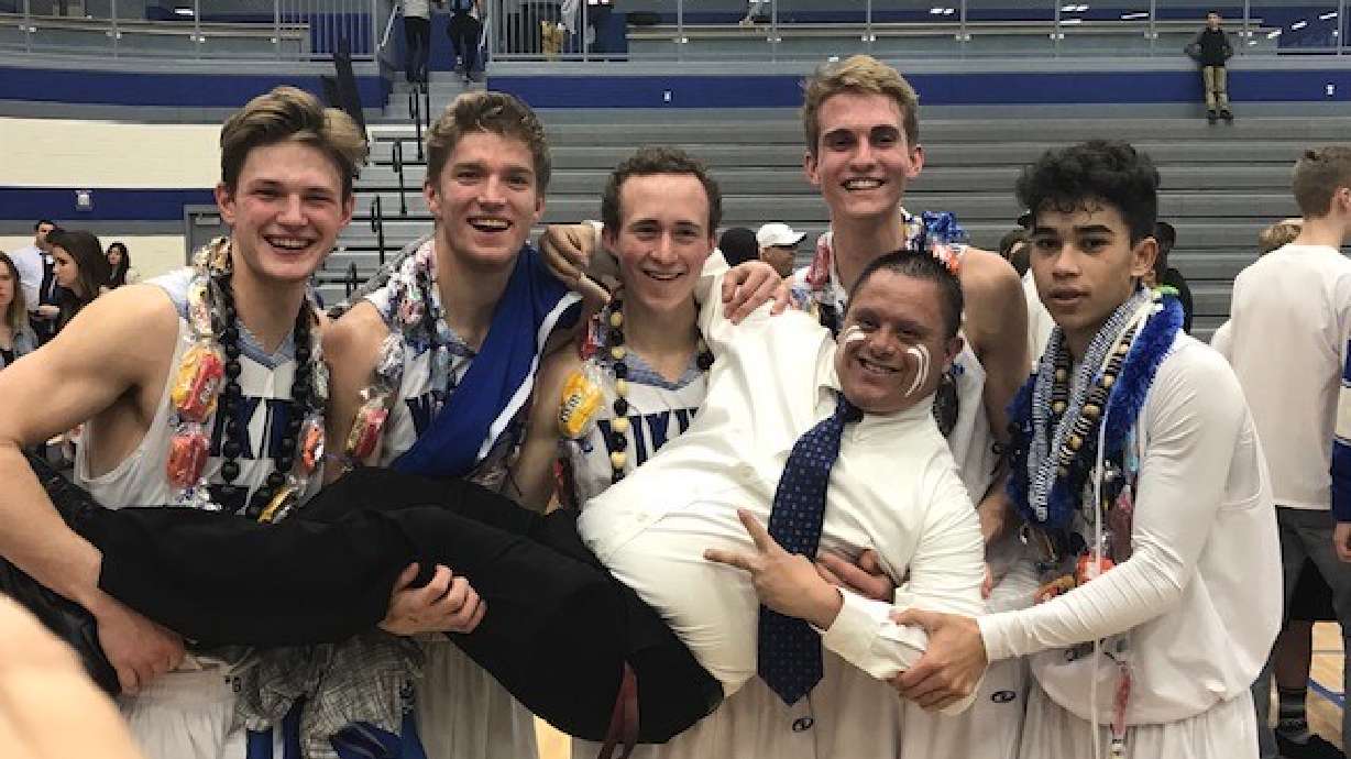 Vaughn Silva poses with Pleasant Grove high school athletes after a game.