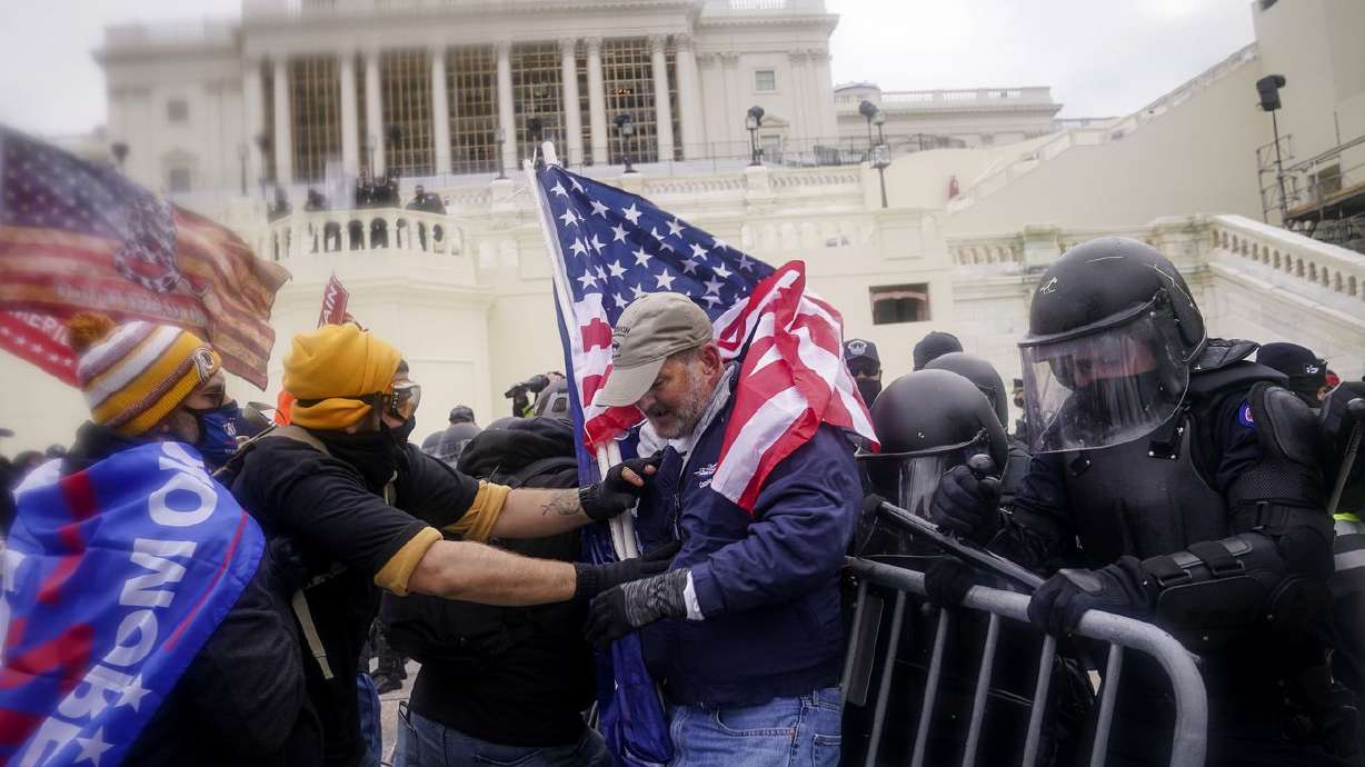 Rioters try to break through a police barrier at the
Capitol on Jan. 6, 2021, in Washington. A recent poll shows 10% of
Utah voters say they support the actions of those who broke into
the Capitol on Jan. 6 of last year, while 82% say they do not
support them.