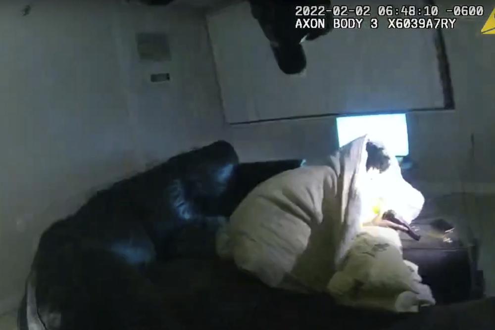 In this image taken from police body camera video and released by the city of Minneapolis, 22-year-old Amir Locke wrapped in a blanket on a couch holding a gun moments before he was fatally shot by police as they were executing a search warrant in a homicide investigation on Wednesday in Minneapolis.