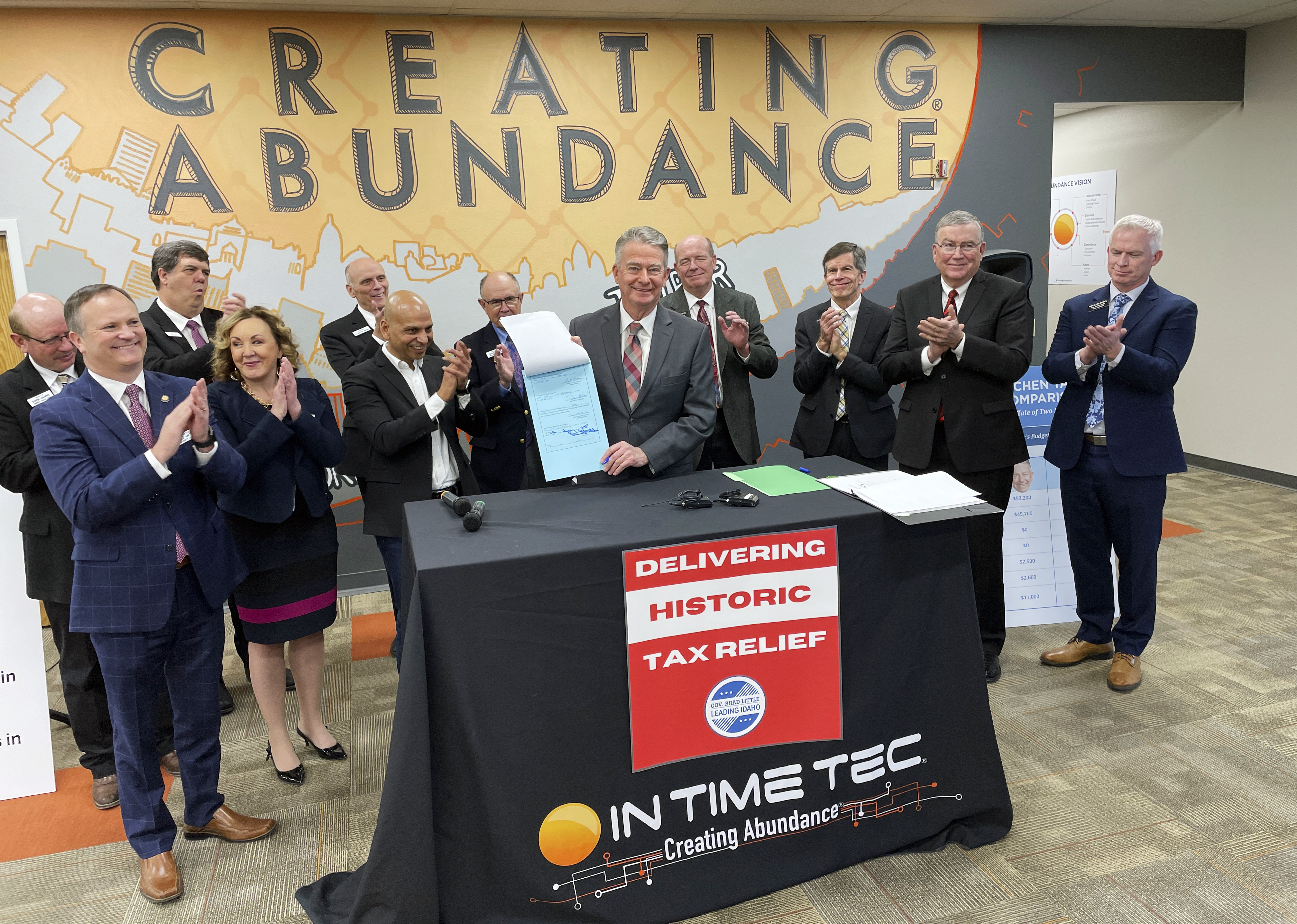 Idaho Gov. Brad Little, center, poses for photos with In Time Tec CEO Jeet Kumar, middle left, and Republican leaders from the House and Senate, after he signed into law a $600 million tax cut, the biggest tax cut in the state's history, at software company In Time Tec in Meridian, Idaho, Friday.