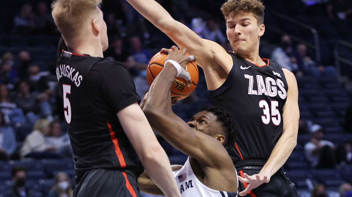 Brigham Young Cougars forward Atiki Ally Atiki (4) is defended by Gonzaga Bulldogs guard Martynas Arlauskas (5) and Gonzaga Bulldogs guard Will Graves (35) in Provo on Saturday, Feb. 5, 2022.