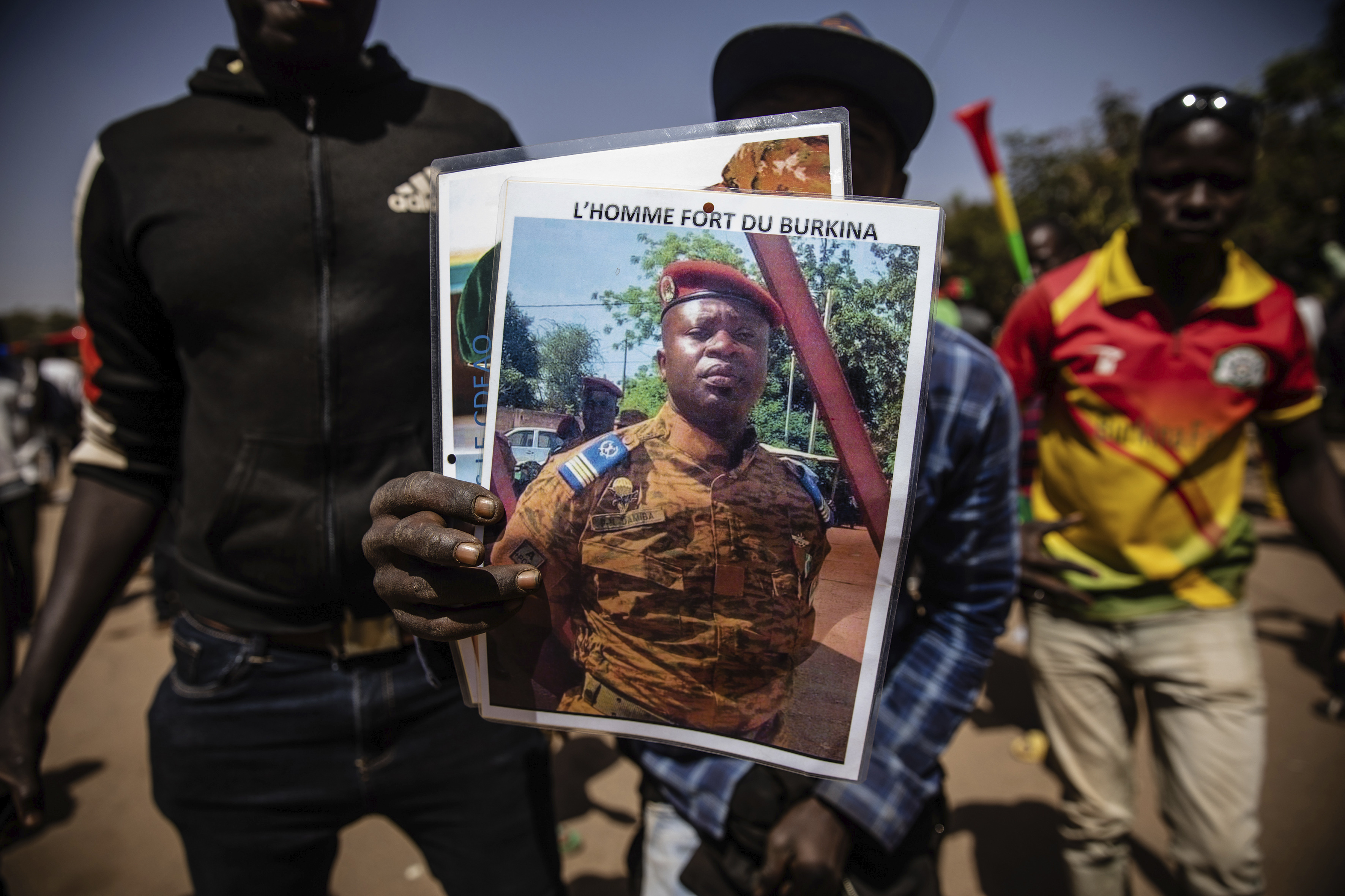 A man holds a portrait of Lt. Col. Paul Henri Sandaogo Damiba who has taken the reins of Burkina Faso, in Ouagadougou, Jan. 25.