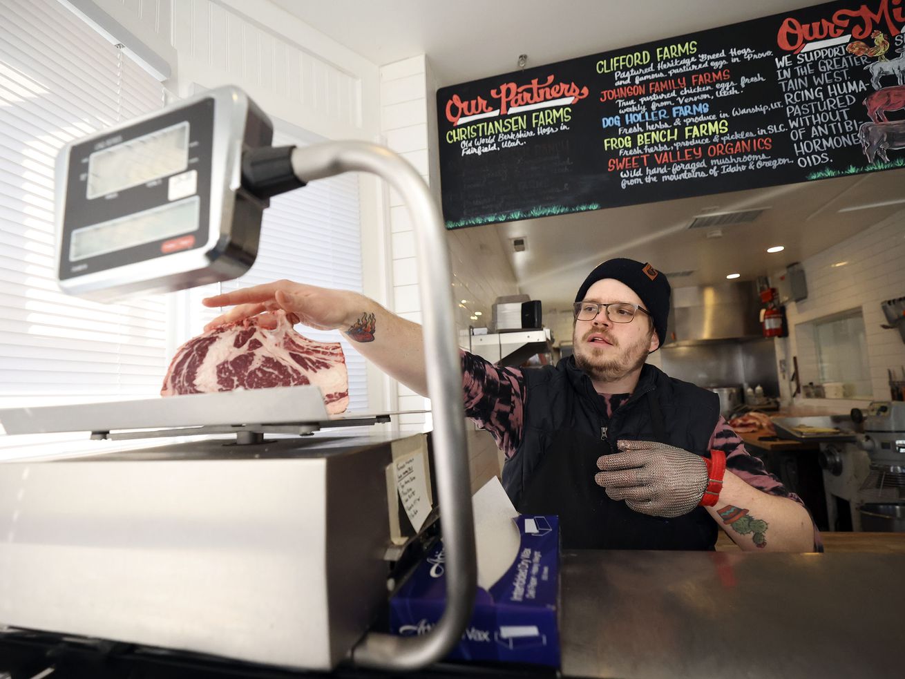 Butcher Jackson Hohler weighs a cut of ribeye for a customer at Beltex Meats in Salt Lake City on Friday.