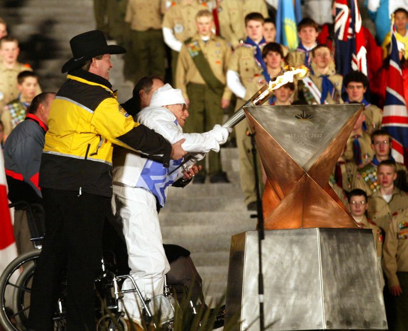 Gov. Mike Leavitt helps Marion Winn light the Olympic
cauldron at the Capitol on Feb. 7, 2002.