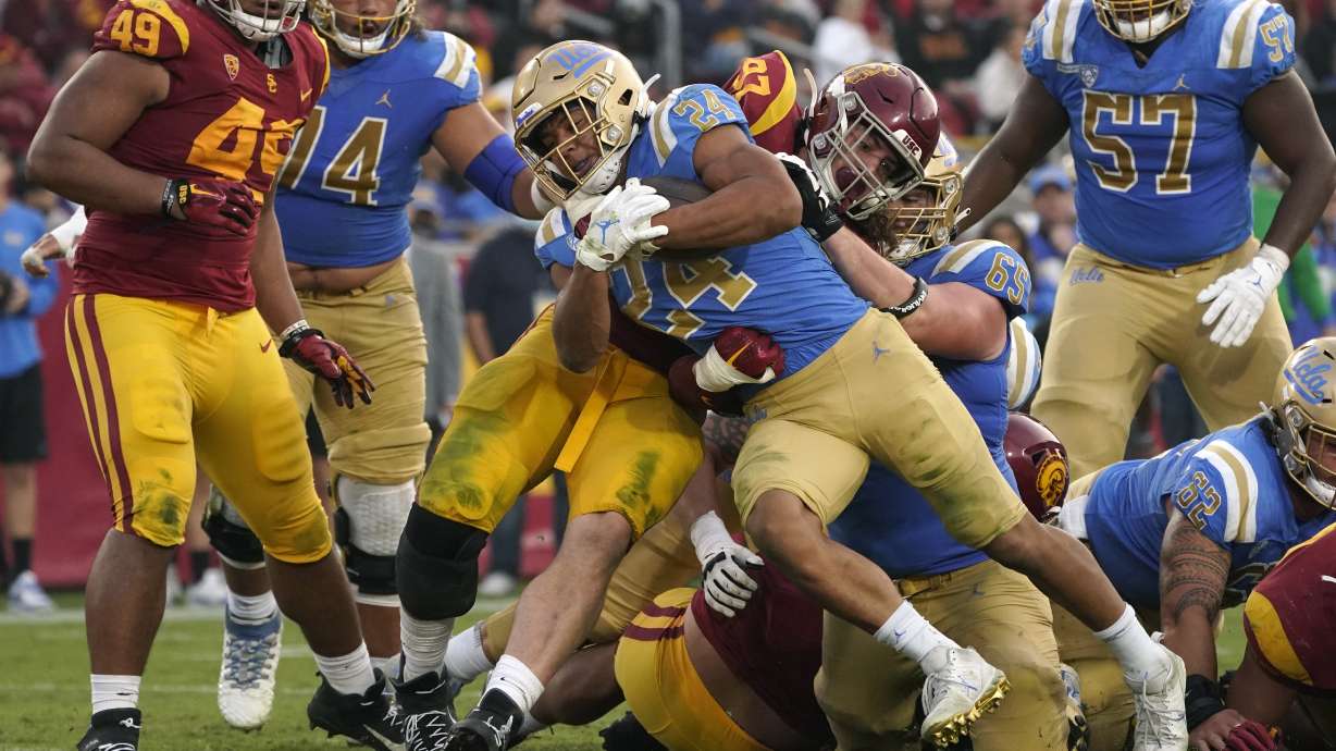 UCLA running back Zach Charbonnet (24) runs the ball in for a touch down as Southern California defensive lineman Jacob Lichtenstein (97) tries to stop him during the second half of an NCAA college football game Saturday, Nov. 20, 2021, in Los Angeles.