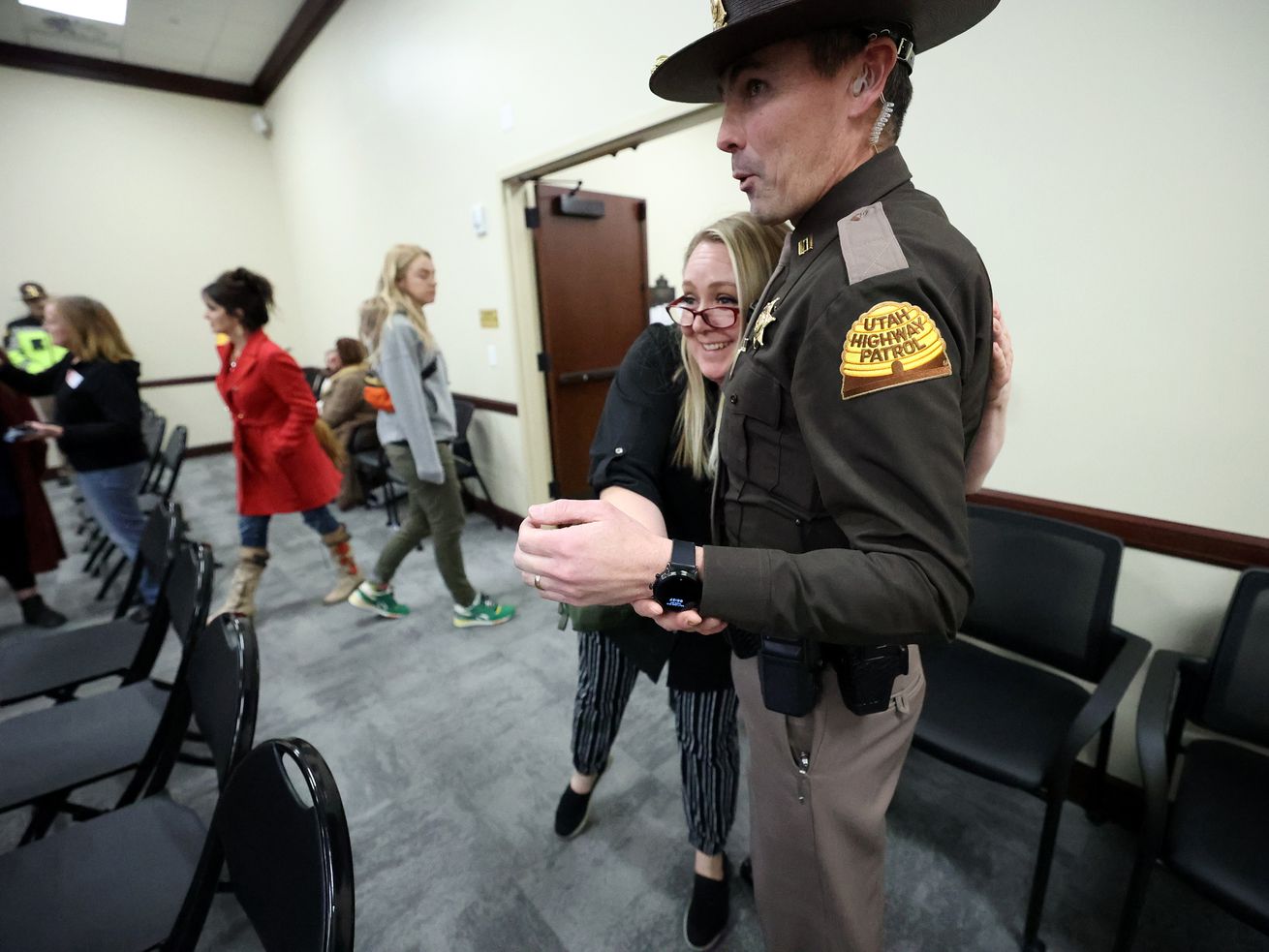 A woman hugs a UHP trooper after SB88 was held after
residents showed up to express feelings on digital driver license
amendments in the House Public Utilities, Energy and Technology
Committee hearing in the Senate building at the Capitol in Salt
Lake City on Monday.
