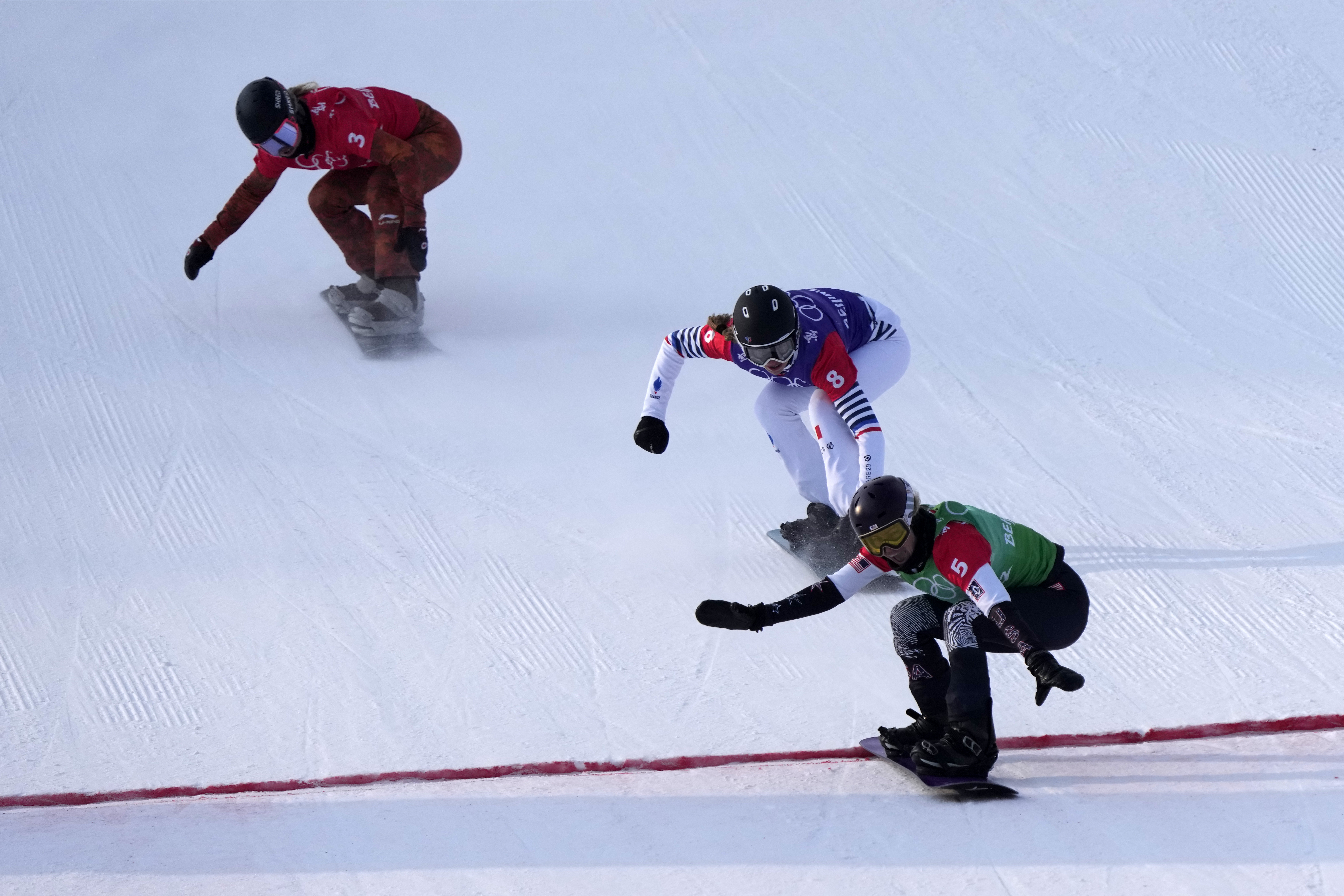 United States' Lindsey Jacobellis (5), followed by France's Chloe Trespeuch (8) and Canada's Meryeta O'Dine (3) crosses the finish line to win a gold medal during the women's cross final at the 2022 Winter Olympics, Wednesday, in Zhangjiakou, China. 
