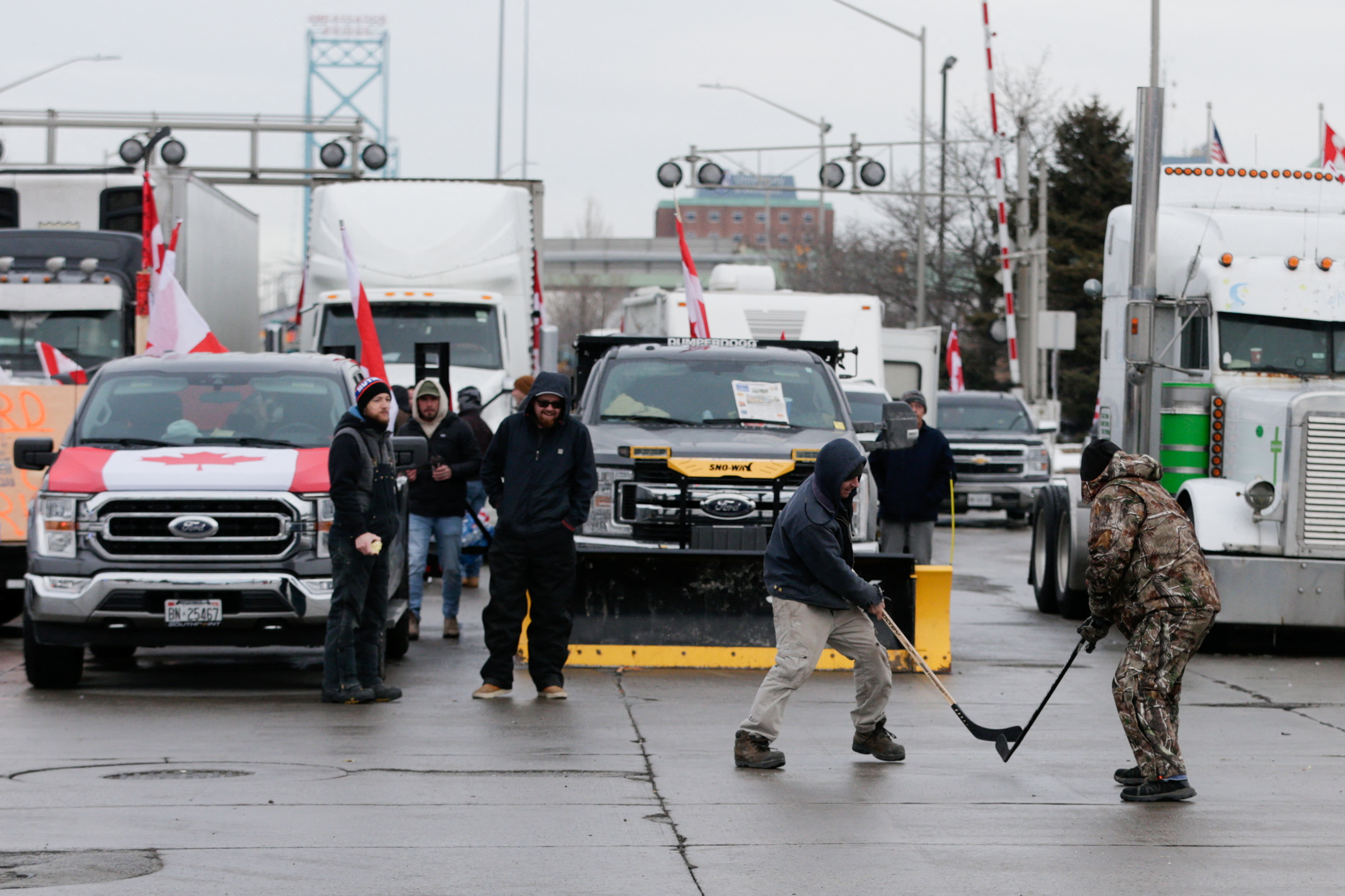 People play hockey while vehicles block the route leading from the Ambassador Bridge, linking Detroit and Canada, as truckers and their supporters continue to protest against COVID-19 vaccine mandates, in Windsor, Ontario, Canada, on Wednesday. 
