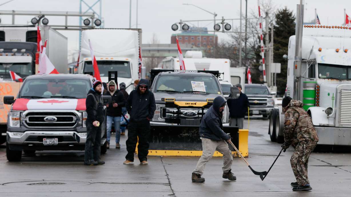 People play hockey while vehicles block the route leading from the Ambassador Bridge, linking Detroit and Canada, as truckers and their supporters continue to protest against COVID-19 vaccine mandates, in Windsor, Ontario, Canada, on Wednesday.