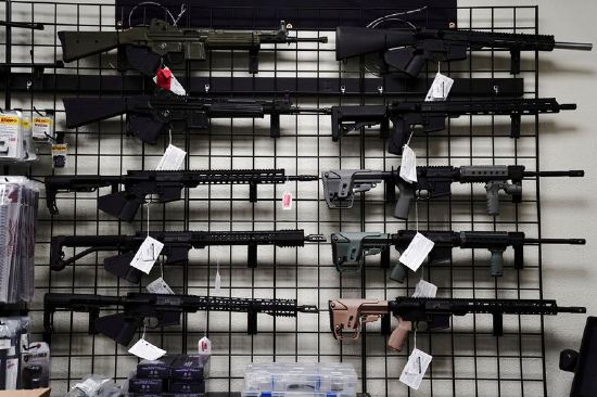 Rifles are displayed for sale at Firearms Unknown, a gun store in Oceanside, California, April 12, 2021. The Los Angeles County district attorney wants credit card companies to halt payments for online purchases of ghost guns.