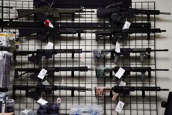 Rifles are displayed for sale at Firearms Unknown, a gun store in Oceanside, California, April 12, 2021. The Los Angeles County district attorney wants credit card companies to halt payments for online purchases of ghost guns.