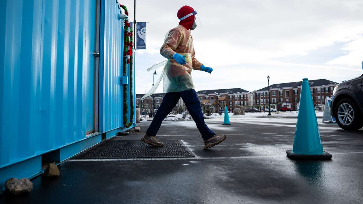 Health care worker Bob Ekoh administers COVID-19 tests at City Hall in Herriman on Jan. 6. Health officials reported another 15 COVID-19 deaths and 2,062 new coronavirus cases on Wednesday as the seven-day rolling average continues to decrease.