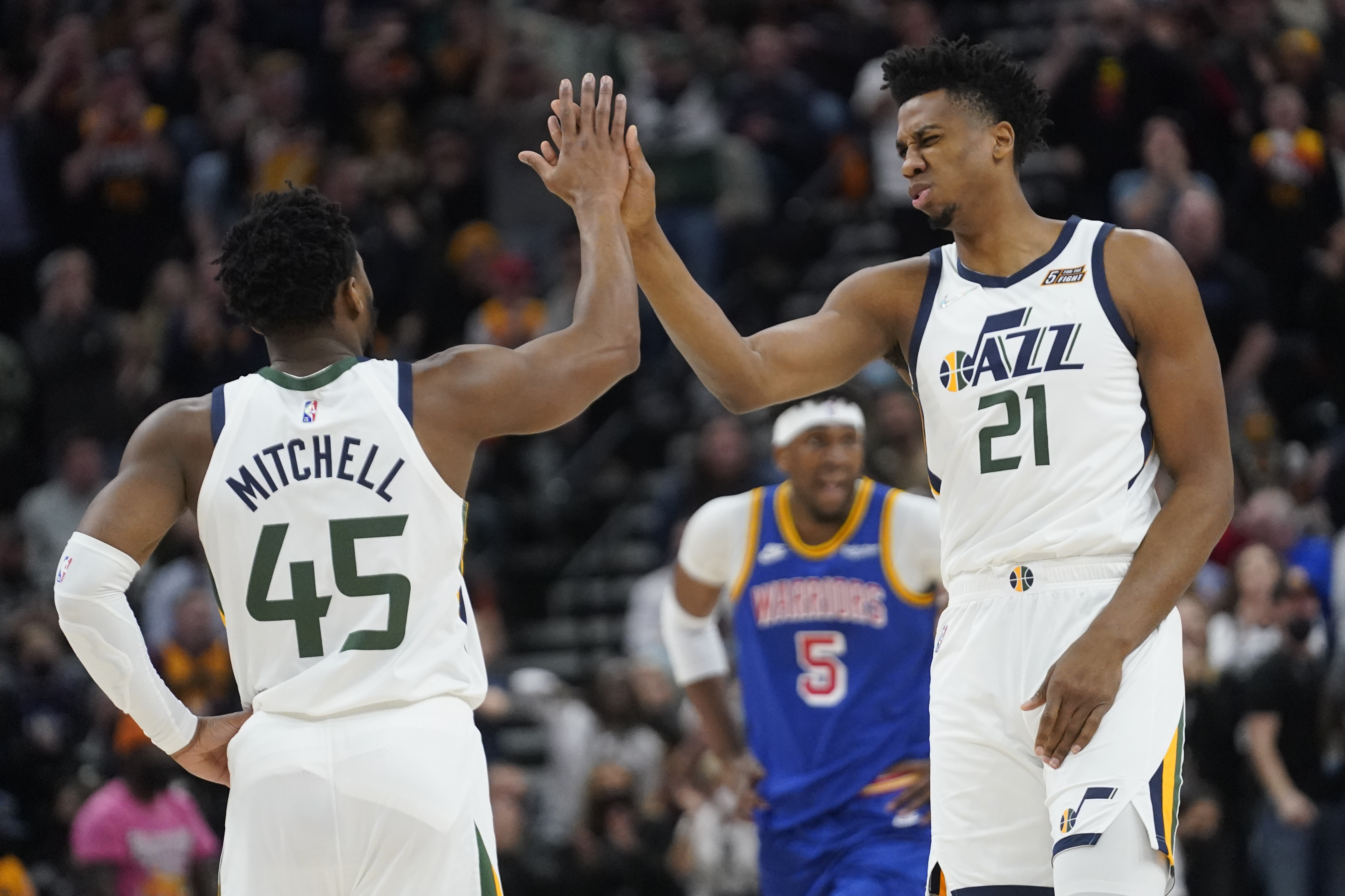 Utah Jazz's Donovan Mitchell (45) and Hassan Whiteside (21) high-five during the first half of the team's NBA basketball game against the Golden State Warriors on Wednesday, Feb. 9, 2022, in Salt Lake City.