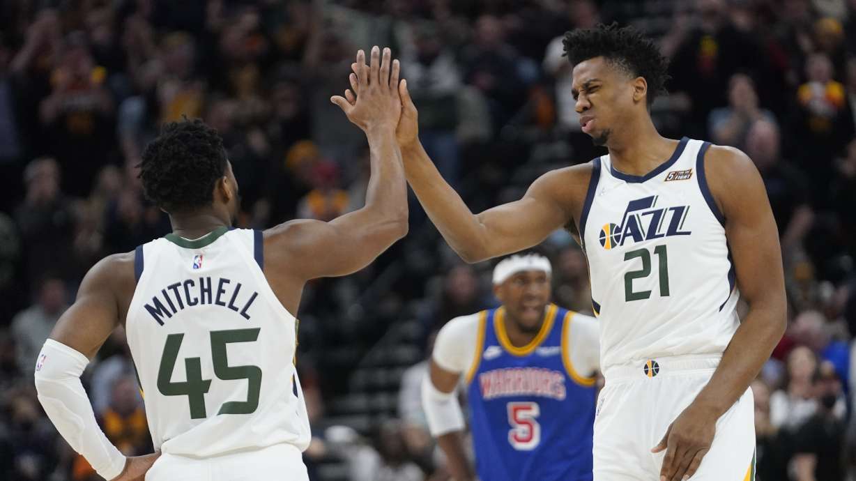 Utah Jazz's Donovan Mitchell (45) and Hassan Whiteside (21) high-five during the first half of the team's NBA basketball game against the Golden State Warriors on Wednesday, Feb. 9, 2022, in Salt Lake City.